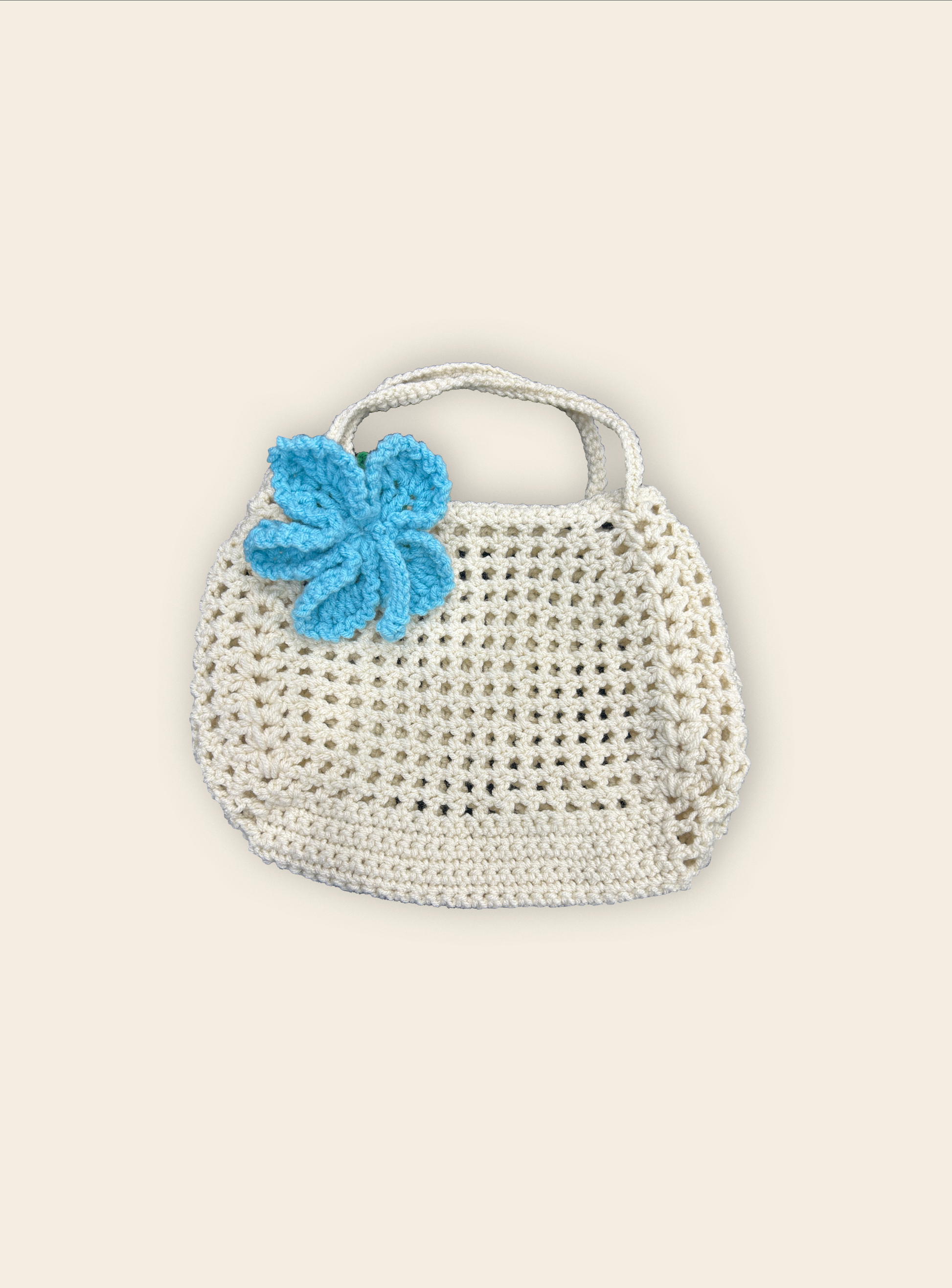 Crocheted handbag with a blue flower on a light beige background